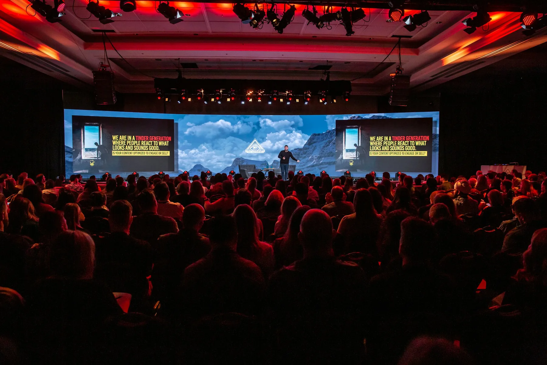 A packed audience watching a creator keynote on a large conference stage